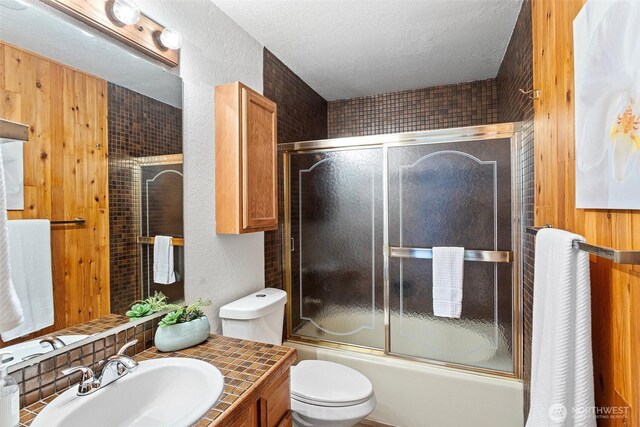 12840 SE 40th Ct Unit A4, Bellevue, WA 98006 - bathroom with vanity, toilet, combined bath / shower with glass door, a textured wall, and a textured ceiling