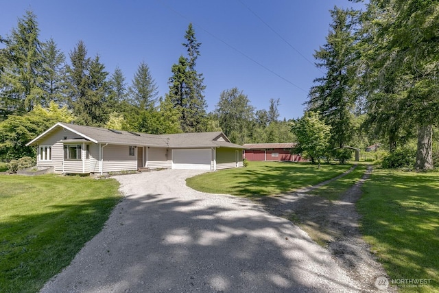 21709 Jordan Rd, Arlington, WA 98223 - ranch-style house with gravel driveway, an attached garage, a front yard, and view of scattered trees
