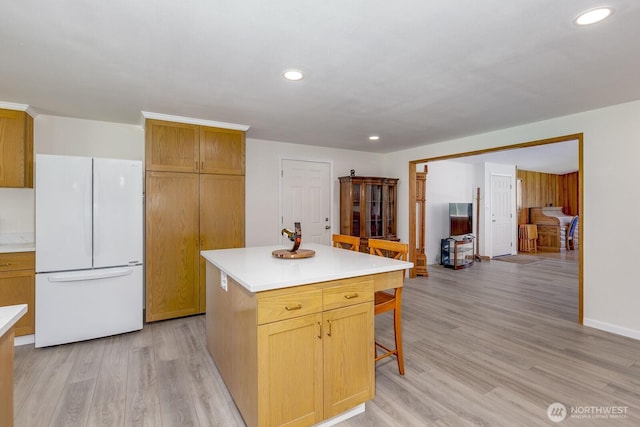 21709 Jordan Rd, Arlington, WA 98223 - kitchen featuring freestanding refrigerator, a breakfast bar, light countertops, light wood-style floors, and recessed lighting