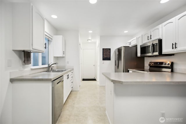 8906 161st St E, Puyallup, WA 98375 - kitchen featuring stainless steel appliances, a sink, recessed lighting, white cabinets, and a peninsula