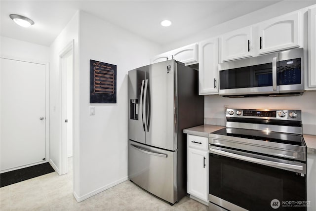8906 161st St E, Puyallup, WA 98375 - kitchen with stainless steel appliances, white cabinets, light tile patterned floors, baseboards, and recessed lighting