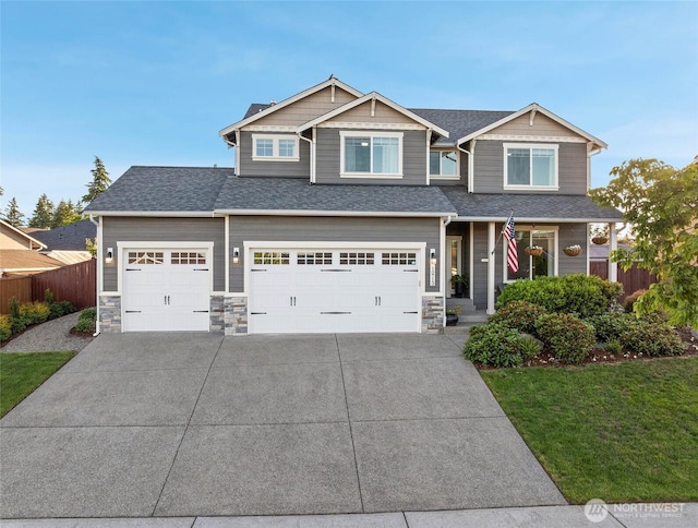 10713 Palisades St SE, Yelm, WA 98597 - view of front of property with concrete driveway, stone siding, roof with shingles, and an attached garage