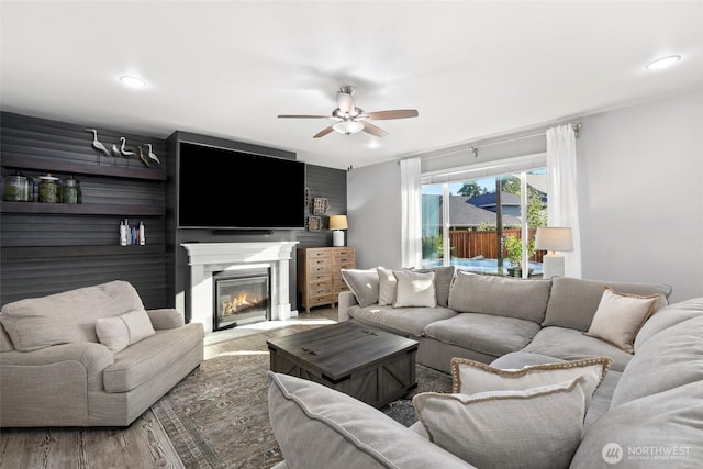 10713 Palisades St SE, Yelm, WA 98597 - living area with ceiling fan, wood finished floors, a glass covered fireplace, and recessed lighting