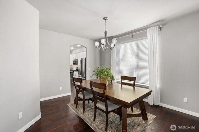 10713 Palisades St SE, Yelm, WA 98597 - dining space featuring a chandelier, baseboards, dark wood finished floors, and arched walkways