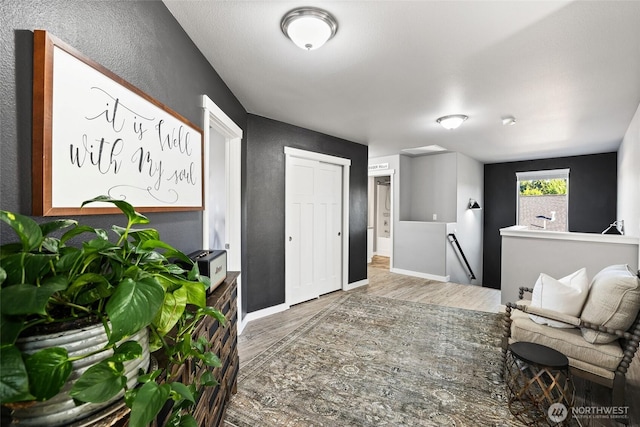 10713 Palisades St SE, Yelm, WA 98597 - living area with wood finished floors, a textured wall, and baseboards