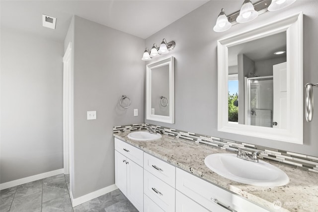 10713 Palisades St SE, Yelm, WA 98597 - full bathroom with double vanity, marble finish flooring, baseboards, and a shower with shower door