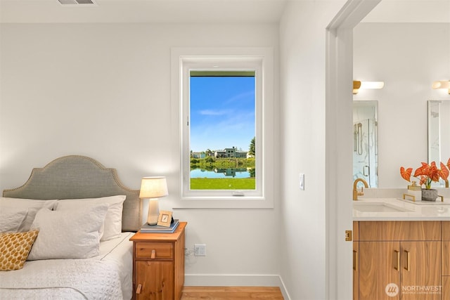 5425 Salish Rd, Blaine, WA 98230 - bedroom featuring a sink, baseboards, and light wood-style flooring