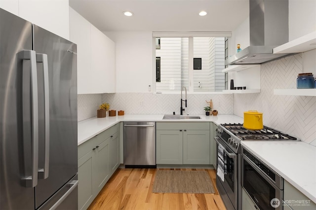 3852 Beach Dr SW Unit A, Seattle, WA 98116 - kitchen with appliances with stainless steel finishes, open shelves, wall chimney range hood, light countertops, and light wood-style flooring
