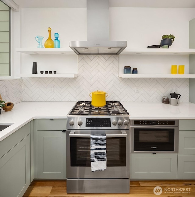3852 Beach Dr SW Unit A, Seattle, WA 98116 - kitchen with open shelves, wall chimney range hood, stainless steel appliances, and backsplash