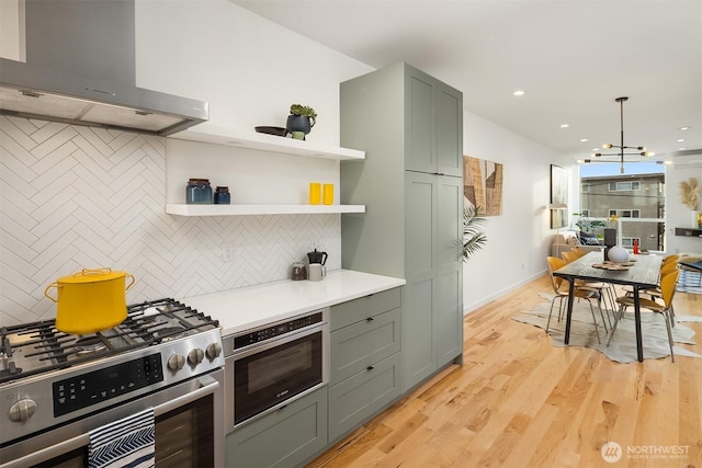 3852 Beach Dr SW Unit A, Seattle, WA 98116 - kitchen featuring wall chimney exhaust hood, stainless steel gas stove, decorative backsplash, light countertops, and recessed lighting