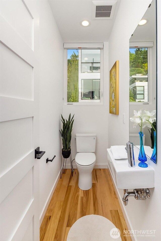 3852 Beach Dr SW Unit A, Seattle, WA 98116 - half bathroom featuring plenty of natural light and wood finished floors