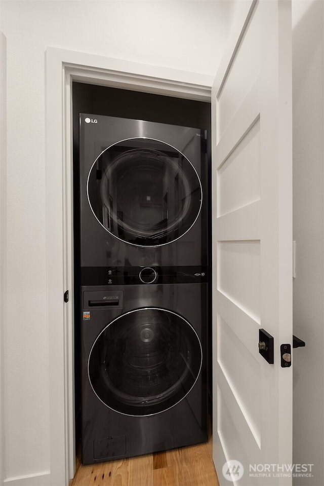 3852 Beach Dr SW Unit A, Seattle, WA 98116 - washroom with estacked washer and dryer and wood finished floors