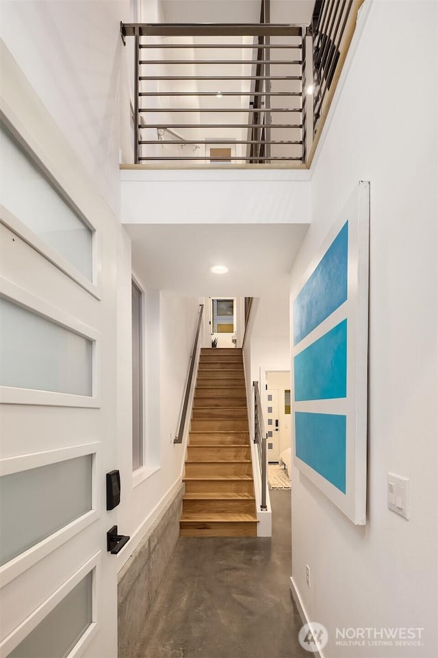 3852 Beach Dr SW Unit A, Seattle, WA 98116 - staircase featuring finished concrete floors and a towering ceiling