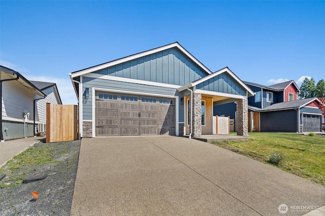 2114 Hawks View Ln, Winlock, WA 98596 - view of front facade featuring stone siding, an attached garage, board and batten siding, and driveway