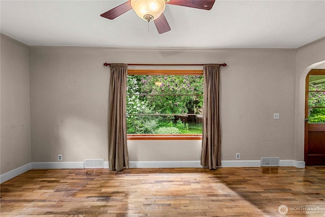 1361 Mission Creek Rd, Cashmere, WA 98815 - unfurnished room featuring arched walkways, wood finished floors, ceiling fan, and baseboards
