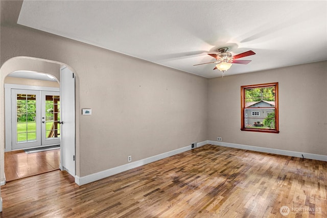 1361 Mission Creek Rd, Cashmere, WA 98815 - spare room with arched walkways, wood finished floors, a ceiling fan, baseboards, and french doors