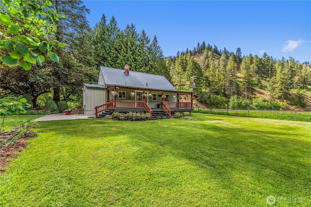 1361 Mission Creek Rd, Cashmere, WA 98815 - back of house with a chimney, metal roof, a deck, a patio, and a view of trees