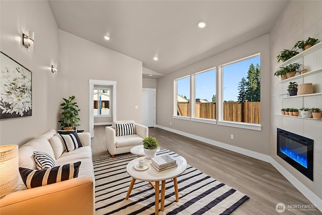 2120 Hawks View Ln, Winlock, WA 98596 - living area with wood finished floors, a glass covered fireplace, lofted ceiling, baseboards, and recessed lighting