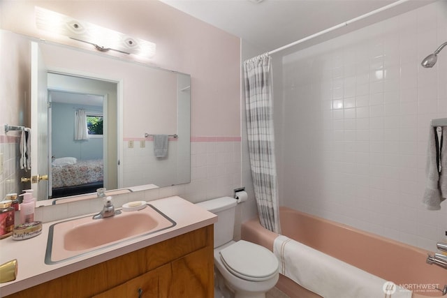 702 Cushing St SW, Olympia, WA 98502 - bathroom with ensuite bath, shower / bath combo with shower curtain, vanity, toilet, and tile walls