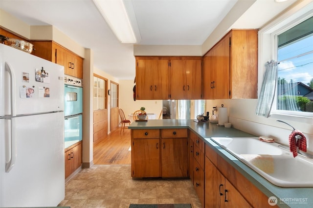 702 Cushing St SW, Olympia, WA 98502 - kitchen with freestanding refrigerator, double wall oven, a peninsula, and brown cabinets