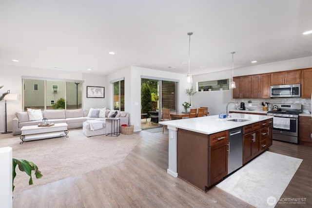 8223 31st Street Ct E, Edgewood, WA 98371 - kitchen with stainless steel appliances, a sink, open floor plan, light wood-style floors, and recessed lighting