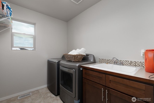 8223 31st Street Ct E, Edgewood, WA 98371 - laundry area with washing machine and clothes dryer, cabinet space, baseboards, and light tile patterned floors