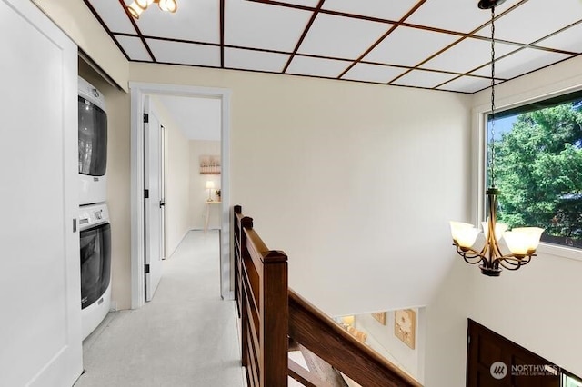 711 NW 120th St, Seattle, WA 98177 - hallway featuring stacked washer and clothes dryer, an upstairs landing, and a chandelier