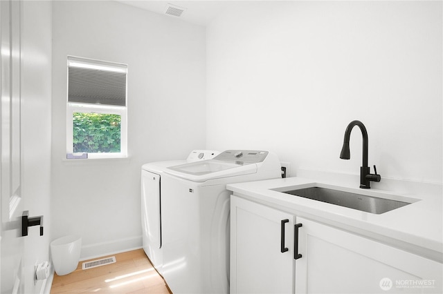 7118 Ashdown Ln SE, Olympia, WA 98513 - laundry area with cabinet space, independent washer and dryer, light wood-style flooring, and baseboards