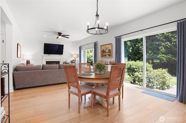 7118 Ashdown Ln SE, Olympia, WA 98513 - dining space with a ceiling fan, a fireplace, light wood finished floors, a chandelier, and recessed lighting