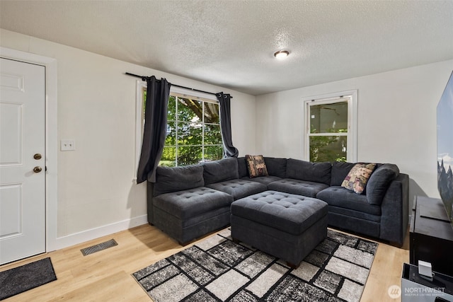 1704 27th Ave, Seattle, WA 98122 - living area with light wood finished floors, a textured ceiling, and baseboards