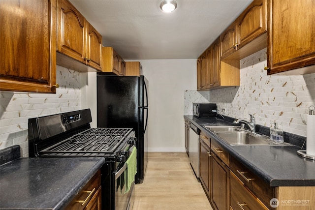 1704 27th Ave, Seattle, WA 98122 - kitchen featuring black appliances, a sink, decorative backsplash, dark countertops, and baseboards