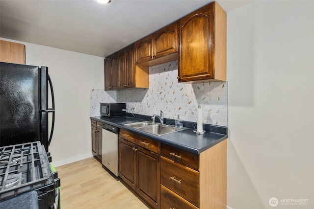 1704 27th Ave, Seattle, WA 98122 - kitchen featuring black appliances, a sink, dark countertops, tasteful backsplash, and light wood-style floors