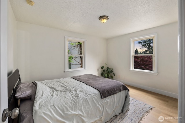 1704 27th Ave, Seattle, WA 98122 - bedroom featuring a textured ceiling, wood finished floors, and baseboards