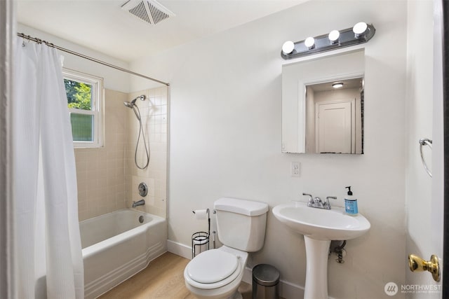 1704 27th Ave, Seattle, WA 98122 - bathroom featuring toilet, shower / tub combo with curtain, wood finished floors, and baseboards