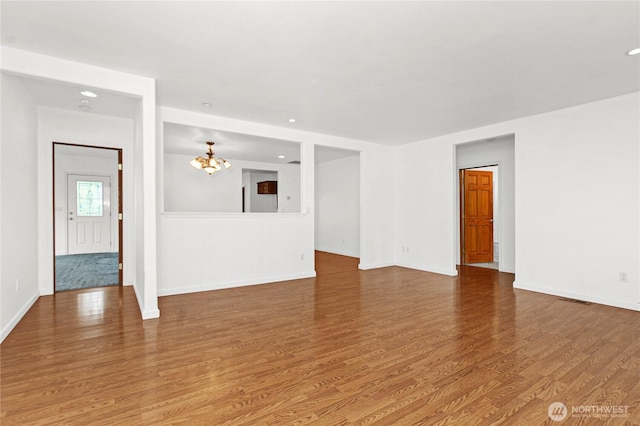 514 Mckinley Ave, Raymond, WA 98577 - unfurnished living room featuring wood finished floors, a chandelier, baseboards, and recessed lighting