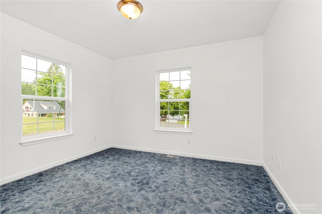 514 Mckinley Ave, Raymond, WA 98577 - empty room featuring healthy amount of natural light, dark colored carpet, and baseboards