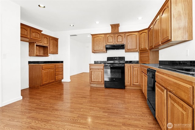 514 Mckinley Ave, Raymond, WA 98577 - kitchen with black appliances, under cabinet range hood, light wood-style floors, recessed lighting, and baseboards