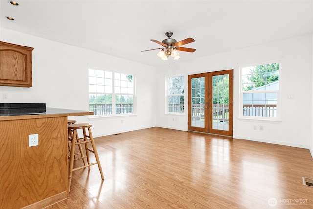 514 Mckinley Ave, Raymond, WA 98577 - unfurnished living room featuring ceiling fan, light wood-style floors, baseboards, and french doors
