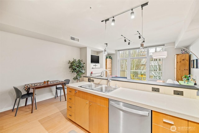 17 W Mercer St Unit 206, Seattle, WA 98119 - kitchen with stainless steel dishwasher, a sink, track lighting, light wood-style floors, and light countertops