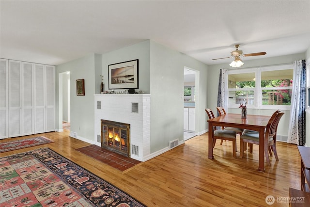 2708 Lynn St, Bellingham, WA 98225 - dining space featuring wood finished floors, ceiling fan, a fireplace, and baseboards