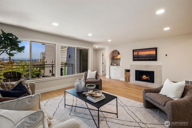 200 James St Unit 206, Edmonds, WA 98020 - living room featuring recessed lighting, a fireplace with flush hearth, light wood-style floors, baseboards, and arched walkways