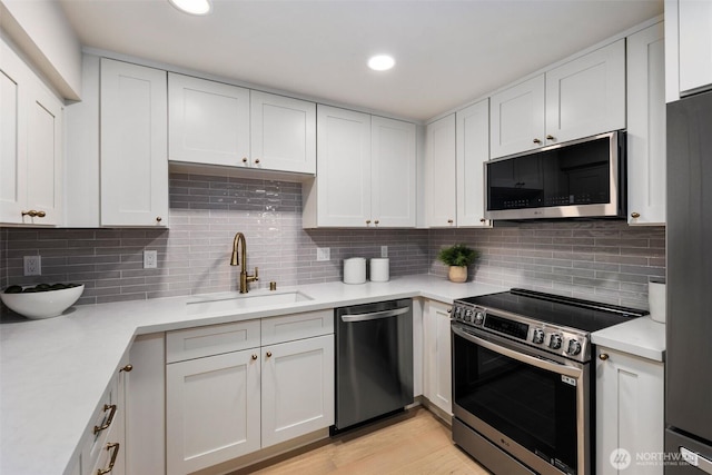 200 James St Unit 206, Edmonds, WA 98020 - kitchen with appliances with stainless steel finishes, a sink, light countertops, white cabinets, and recessed lighting