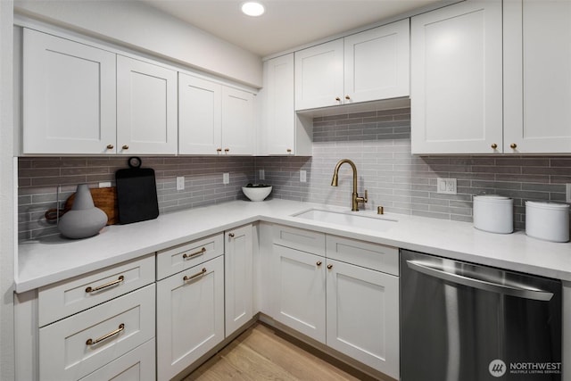 200 James St Unit 206, Edmonds, WA 98020 - kitchen with dishwasher, a sink, light countertops, decorative backsplash, and light wood-style floors