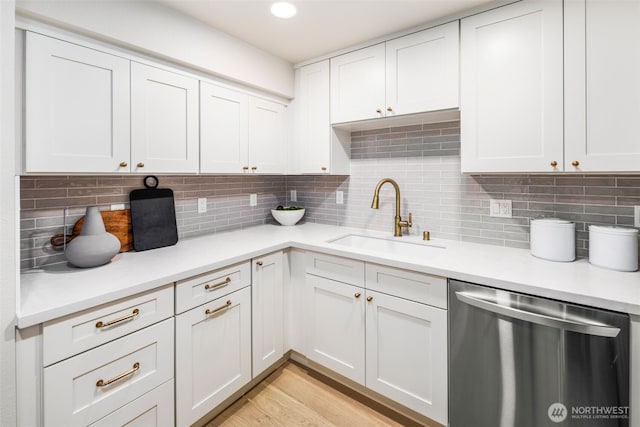 200 James St Unit 206, Edmonds, WA 98020 - kitchen featuring stainless steel dishwasher, a sink, light countertops, tasteful backsplash, and light wood-style floors