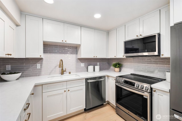200 James St Unit 206, Edmonds, WA 98020 - kitchen with appliances with stainless steel finishes, a sink, white cabinets, light countertops, and recessed lighting