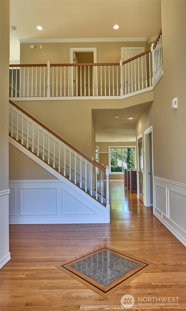 27006 229th Pl SE, Maple Valley, WA 98038 - staircase featuring a decorative wall, wood finished floors, crown molding, recessed lighting, and a wainscoted wall