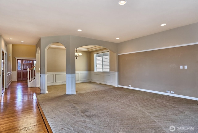 27006 229th Pl SE, Maple Valley, WA 98038 - spare room with wainscoting, arched walkways, recessed lighting, light wood-style flooring, and a decorative wall