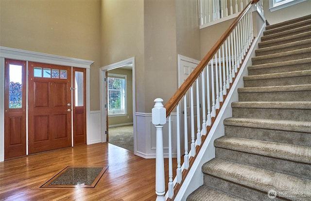 27006 229th Pl SE, Maple Valley, WA 98038 - foyer entrance with wood finished floors, a high ceiling, stairway, and wainscoting