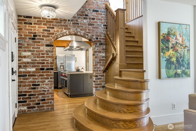 1542 Grand Ave, Seattle, WA 98122 - entryway featuring stairs, arched walkways, light wood-style floors, and baseboards