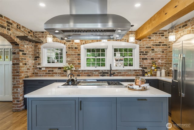 1542 Grand Ave, Seattle, WA 98122 - kitchen with appliances with stainless steel finishes, island exhaust hood, a sink, healthy amount of natural light, and brick wall